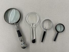 Four magnifying glasses arranged big to small from left to right