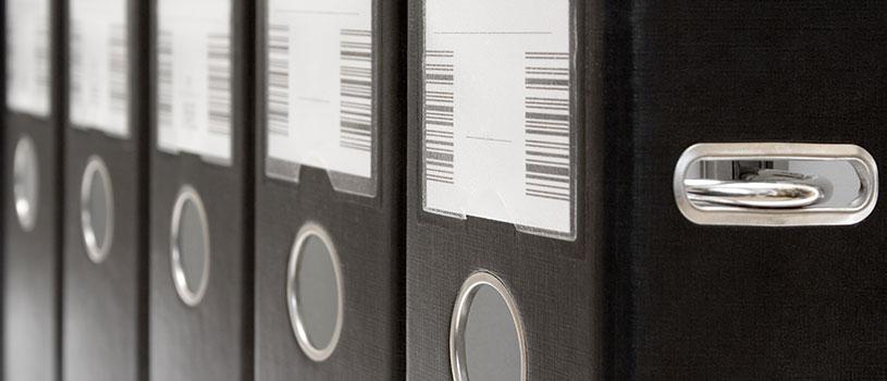 Rows of black binders with barcodes
