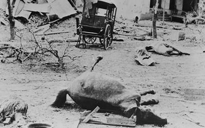 Black and white image of destruction of a Burmese village. 
