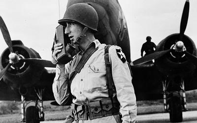 A soldier uses a "walkie-talkie" to communicate during World War II.