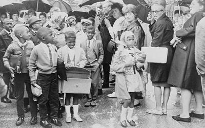 African American children on way to PS204, 82nd Street and 15th Avenue, pass mothers protesting the busing of children to achieve integration.