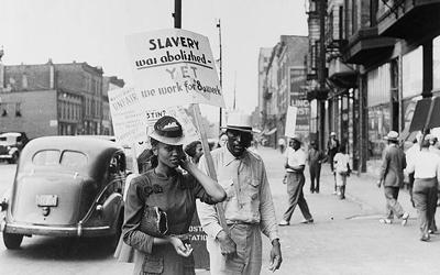 African Americans standing in a picket line outside a midtown business in Chicago, Illinois, in 1941 protesting the wage earned by African Americans compared to others.
