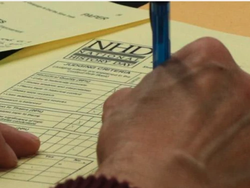 A judge completes a scorecard for National History Day