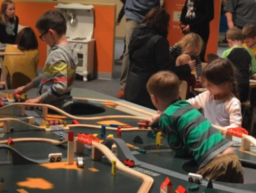 Children play with a track and puzzle at the State Historical Museum of Iowa