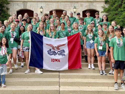 A group of students holding the Iowa state flag for National History Day