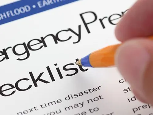 Close up of a hand with a pen using an emergency preparedness checklist