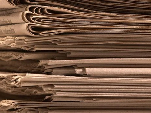 Newspapers stacked together.