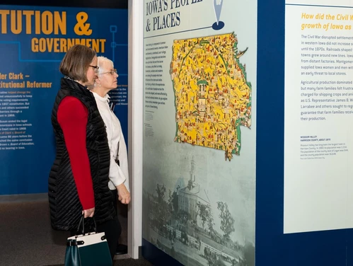 Two adults gaze at an exhibit in the Iowa museum