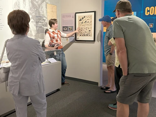 Volunteer giving a guided exhibit tour.