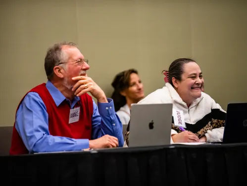 Pictures of two judges with their laptops judging at the State National History Day Contest