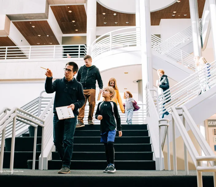 A tour guide shows around a family at the history museum