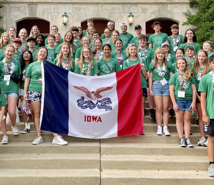 A group of students holding the Iowa state flag for National History Day