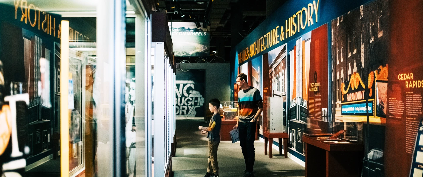 A man and his son visiting the Hollywood in the Heartland exhibit at the State Historical Museum of Iowa.