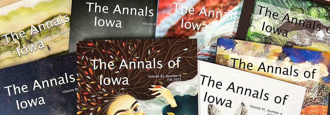 Pile of eight covers of The Annals of Iowa publication featuring artwork by Iowa artists