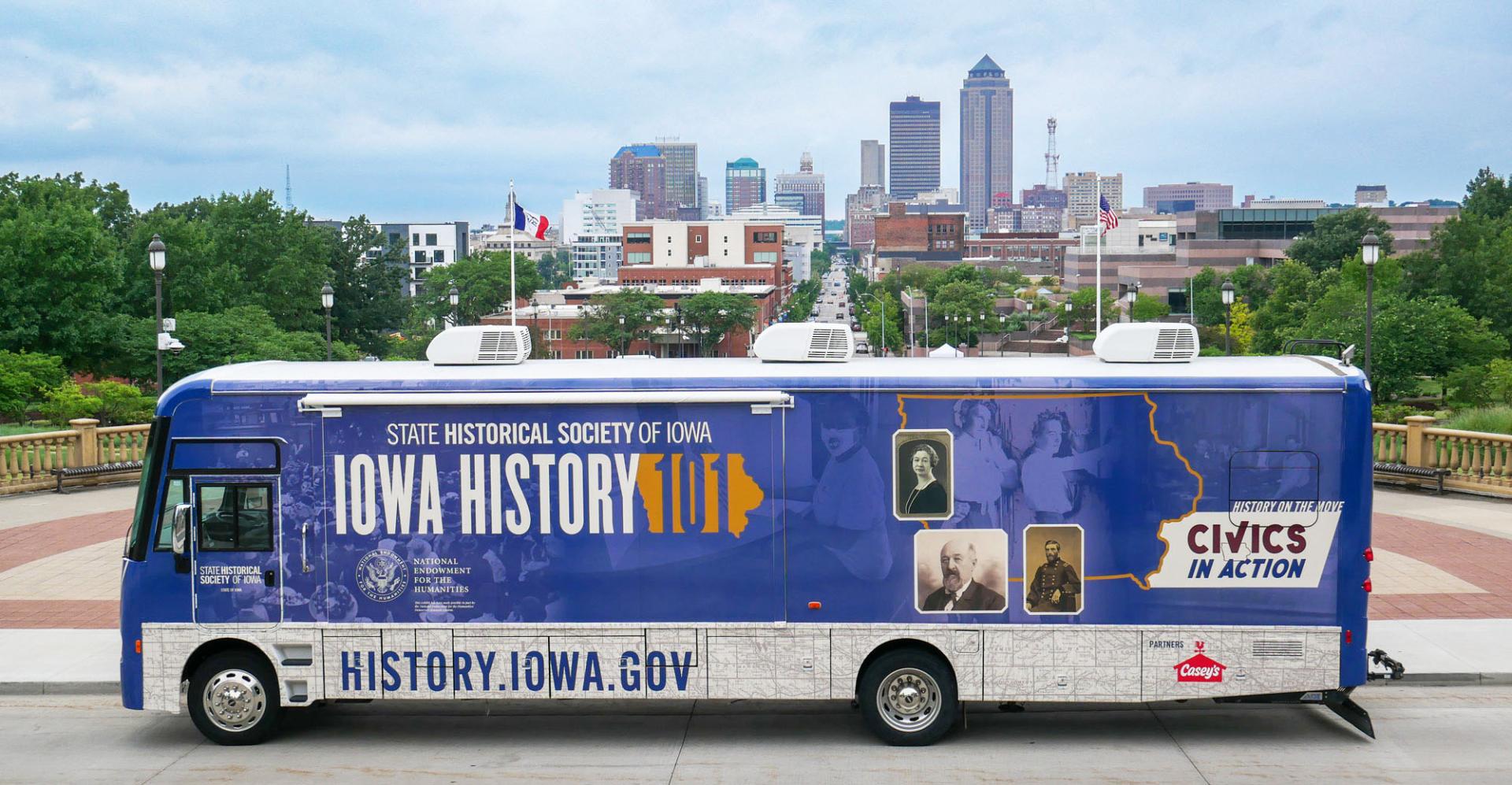 The Mobile Museum 3.0 is parked in front of a view of downtown Des Moines