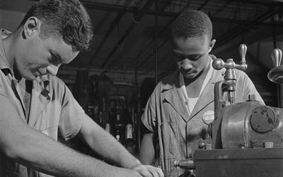 Black and white photograph of Two young men working with the NYA. 