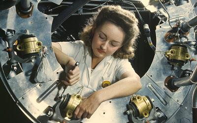 Color image of a woman working on a B-52 bomber.  