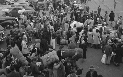 Japanese Americans with their baggage waiting for trains which will take them to Owens Valley.