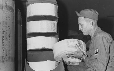 An American soldier prepares a psychological warfare leaflet bomb at a military base in Yokohama, Japan. The bomb type adapter will contain 22,500 (5 x 8) psychological warfare leaflets.