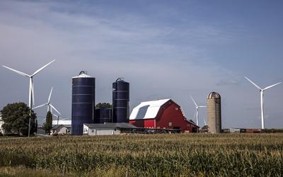 Farm Scene Including a Bright-Red Barn, Three Silos (one vintage, two modern), and Quite Modern Wind Turbines in Hardin County, Iowa