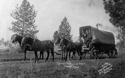 Immigrants in a horse-drawn Conestoga wagon in Central Oregon. 