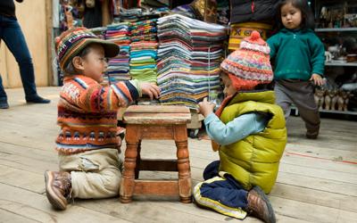 Children playing near artisan materials in Central America