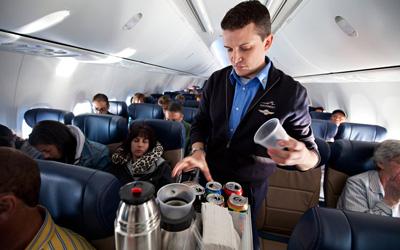 Southwest Airlines Flight Attendant serves beverages on flight