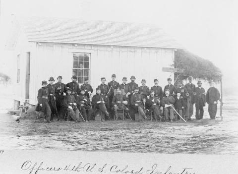 This photograph taken in April 1865 pictures officers of the 4th United States Colored Infantry at Fort Slocum near New York City. There are two rows of men total with seven men seated in the front and sixteen standing in the back. Two African-American NCO’s stand on the very right hand side of the second row. 