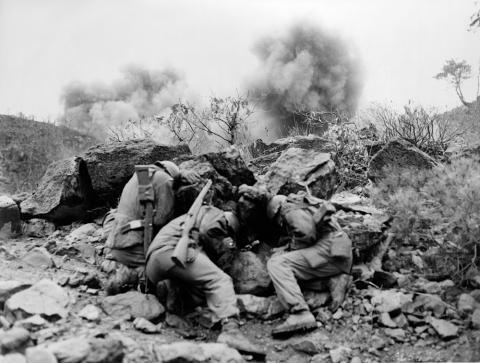  Men of the 3rd Battalion, 34th Infantry Regiment, 35th Infantry Division, covering up behind rocks to shield themselves from exploding mortar shells, near the Hantan River in central Korea