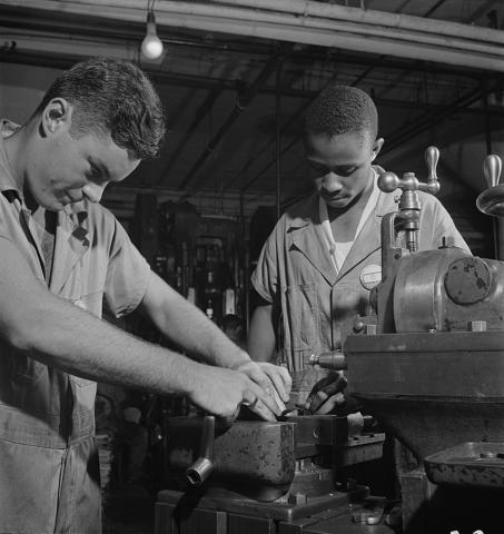 Black and white photograph of Two young men working with the NYA. 