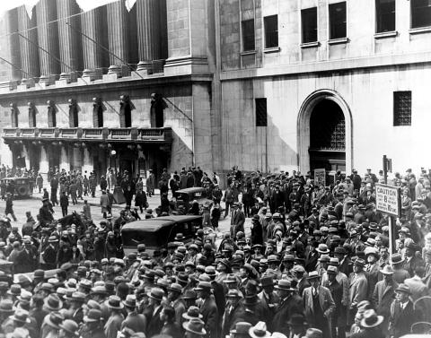 Black and white photograph of a crowd of people standing outside of the New York Stock Exchange after the stock market crash of 1929.