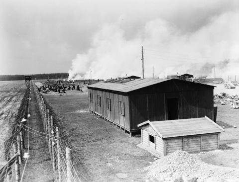 Image shows a small building with barbed wire fencing around it.  It is an image of a concentration camp in Germany.