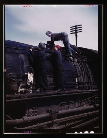 A group of three women cleaning an H-Class locomotive.  