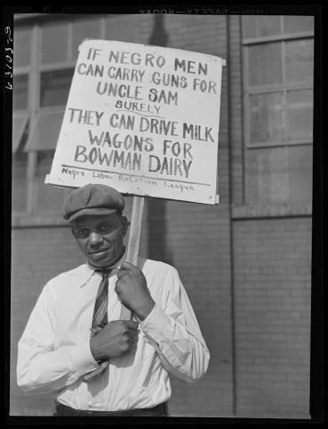 An African American man standing in a picket line for the Negro Labor Relation League with a sign protesting Bowman Dairy in Chicago, Illinois.
