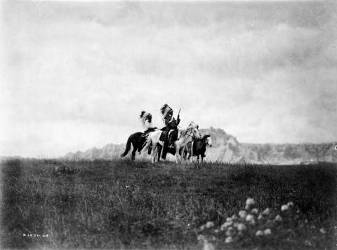 Three Sioux Native Americans on horseback.