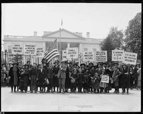 The photo is a black and white image of women and children holding picket signs.  