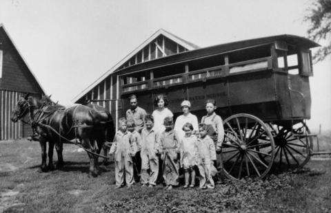 Children standing beside horse-drawn bus