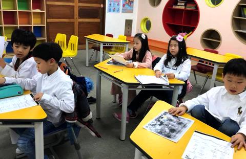 Korean students using books to complete an assignment.