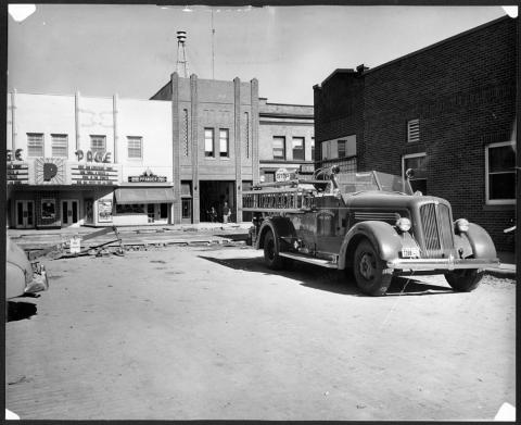 1950s motorized fire truck seen parked in a parking lot with a street construction happening in the background.