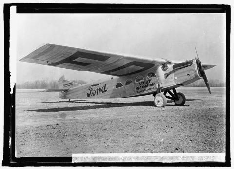 Small, propeller airplane with “Ford” painted on the side.