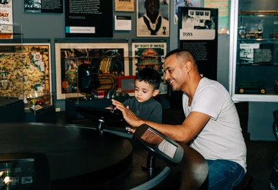 A man and child explore the collection on iPads in the Visible Vault exhibit