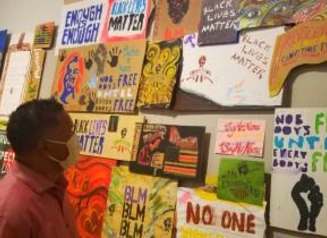 A person looking at a wall filled with signs advocating for civil rights
