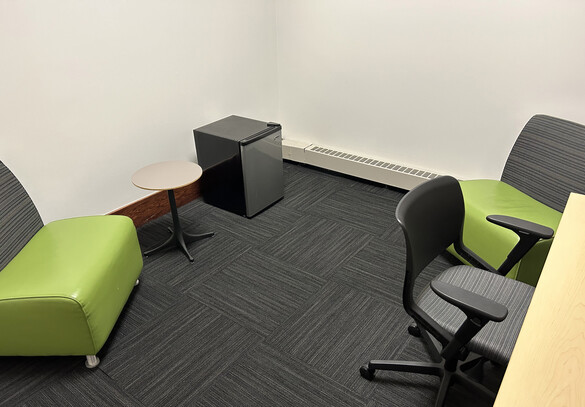 Nursing room with three chairs and a small fridge