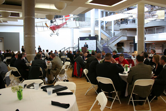 State Historical Building atrium set up for a business conference with tables, a podium, and a presentation screen