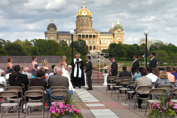 Wedding ceremony on the Cafe Terrace of the State Historical Building with a view of the Iowa State Capitol building.