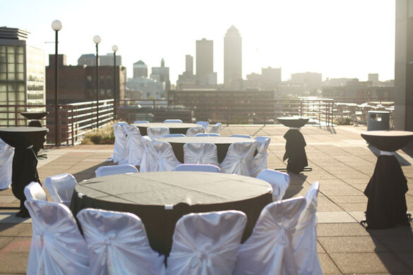 Tables set up on the Cafe Terrace of the State Historical Building with a view of downtown Des Moines.
