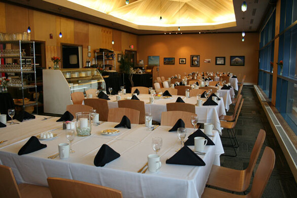 Interior cafe set up for a banquet with tablecloths.
