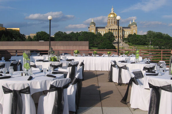 Tables set up on the Cafe Terrace of the State Historical Building with a view of the Iowa State Capitol building.