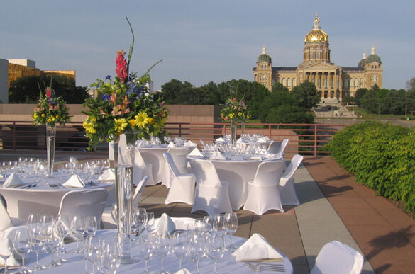 Tables set up on the Cafe Terrace of the State Historical Building with a view of the Iowa State Capitol building.