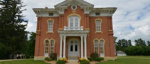 The front entrance and white pillar columns of the Montauk Historic Site home